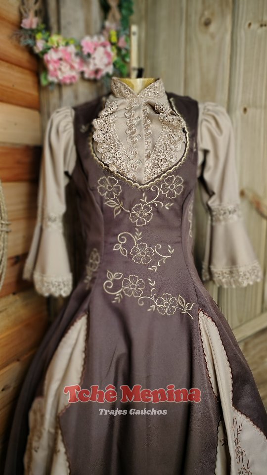 Vestido de prenda marrom e bege com renda delicada e bordado tradicional